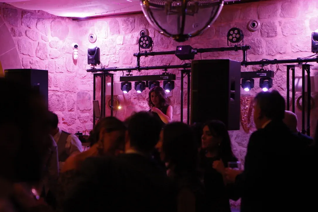 Fiesta en sala de piedra con luces rosas